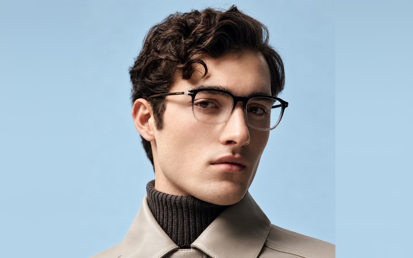 A man wearing slim dark optical frames