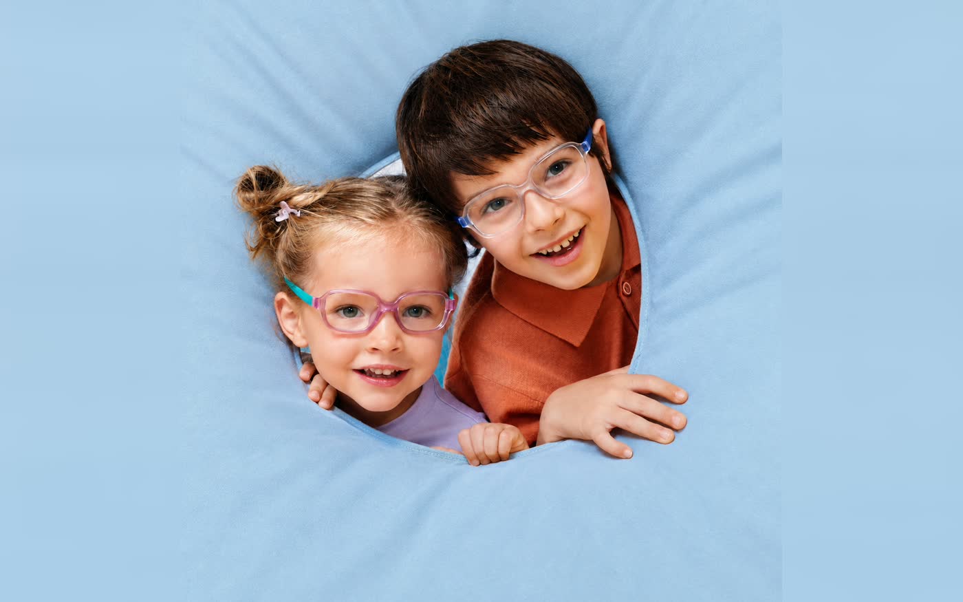 Two smiling children wearing colourful kids frames